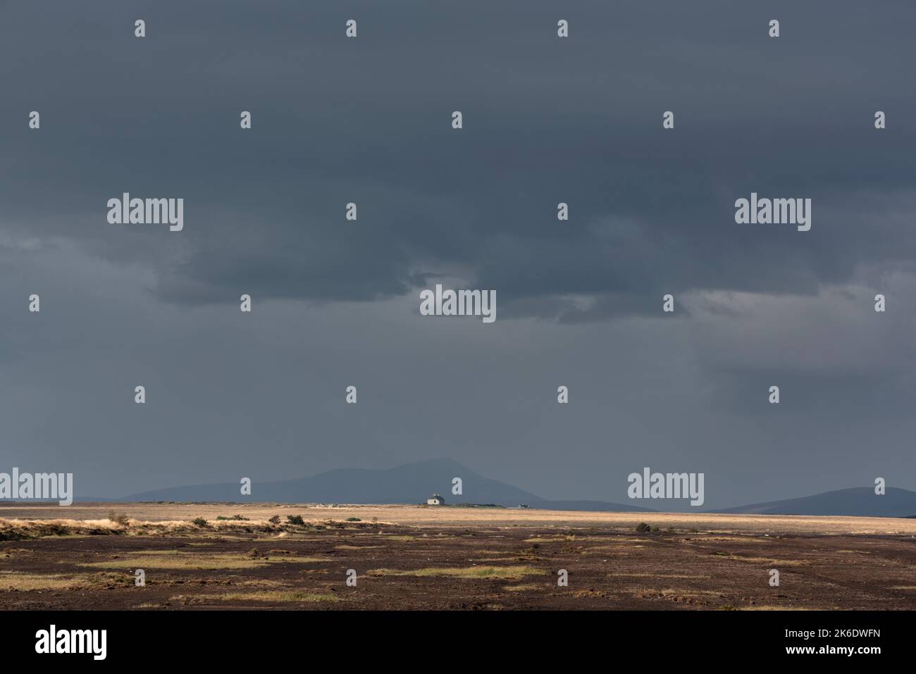 Chalet abandonné au milieu du vaste pays de Bangor Erris Bog, comté de Mayo, Irlande. Des nuages sombres s'accumulent, la pluie arrive. Banque D'Images