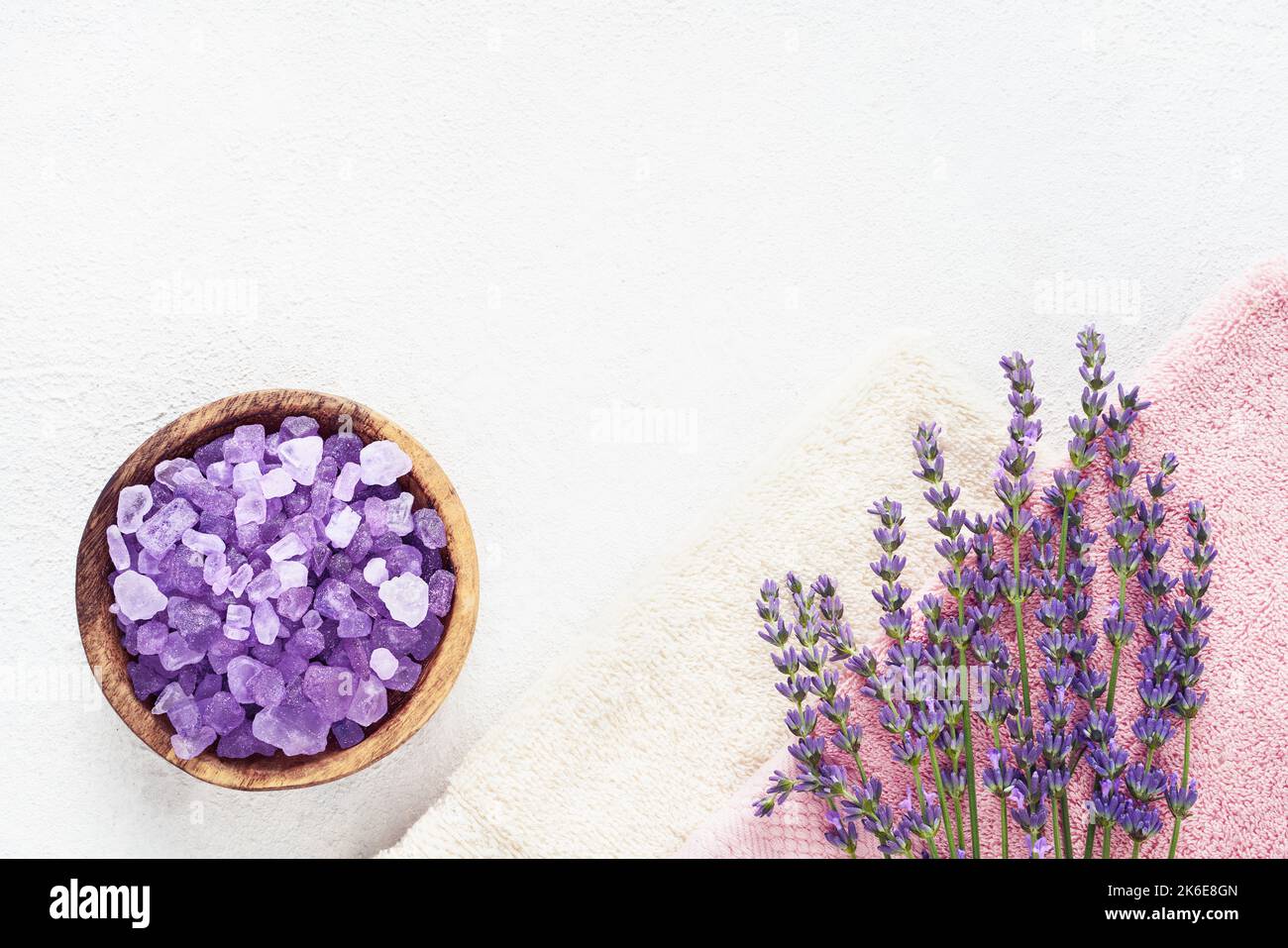 Fleurs de lavande, sel de bain dans un bol en bois et serviettes sur fond clair. SPA, concept de soins du corps. Vue de dessus, espace de copie pour le texte Banque D'Images