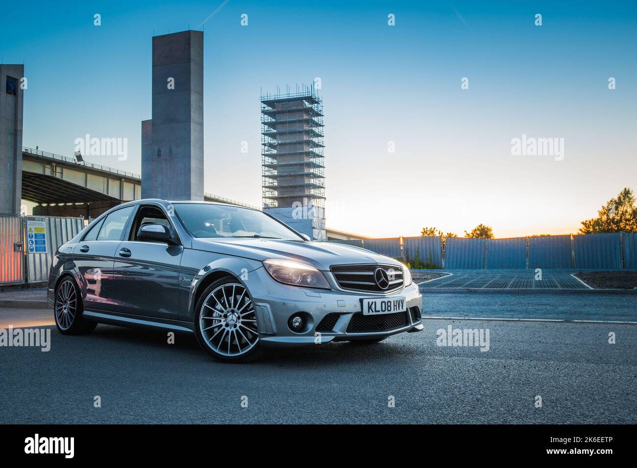 Le profil latéral d'Une Mercedes Benz 2008 C63 AMG Saloon W204 lors D'Une soirée ensoleillée à Manchester Banque D'Images