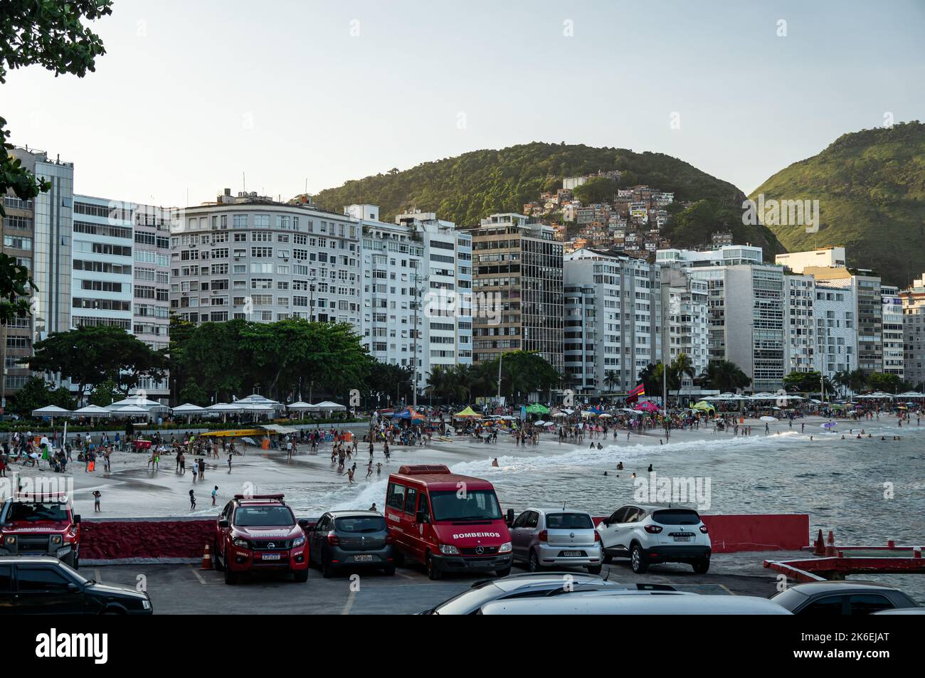 Vue sur la plage de Copacabana côté sud de la côte pleine de touristes avec de nombreux immeubles d'appartements en bord de mer à elle en fin d'après-midi sous le ciel bleu ensoleillé. Banque D'Images