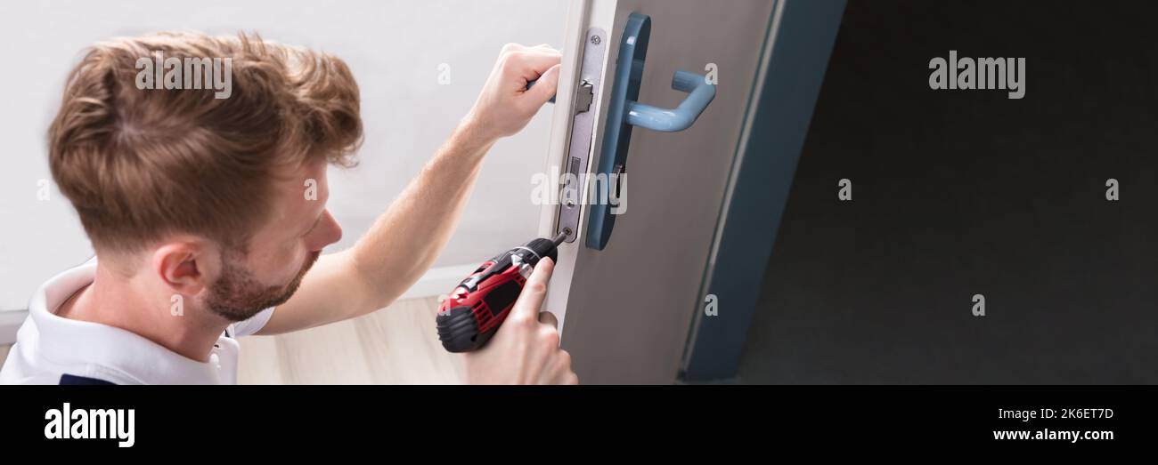 Serrurier pour changer le verrou de porte. Services de technicien de sécurité Banque D'Images