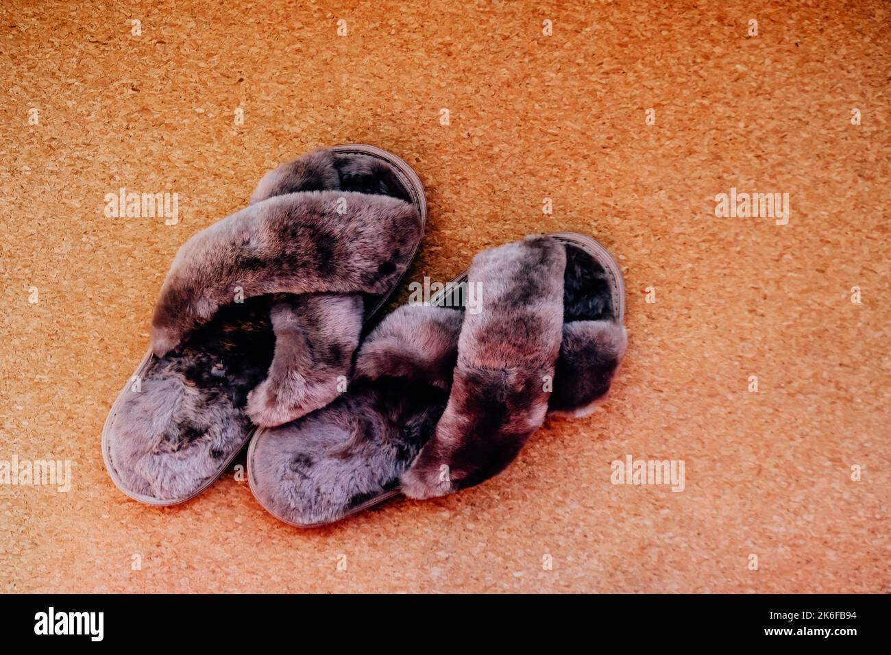 Chaussons femmes maison douillets sur fond de liège Banque D'Images