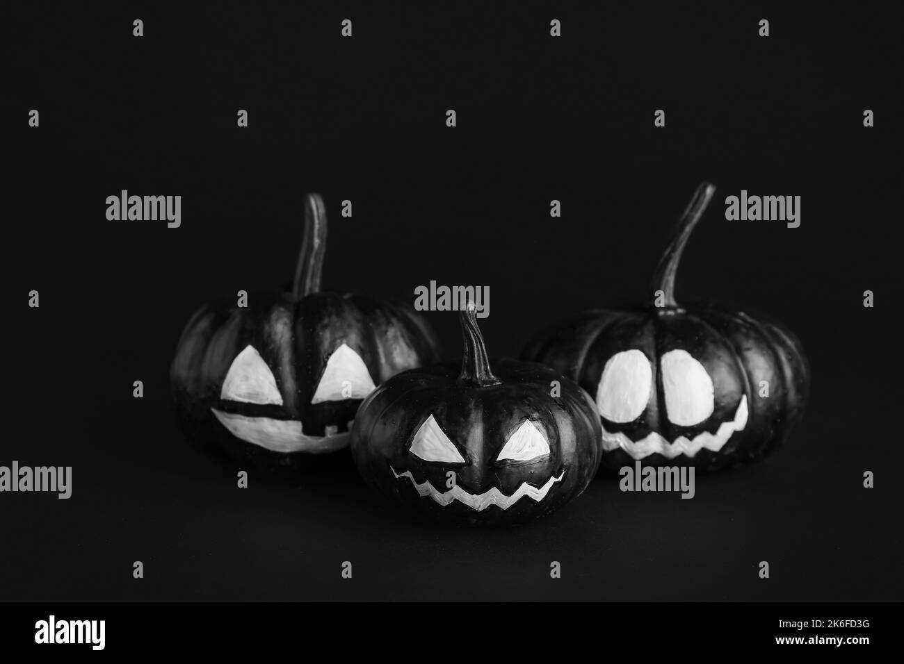 Citrouilles d'Halloween avec visages dessinés sur fond sombre Banque D'Images