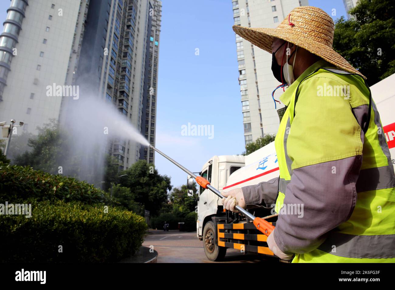 LIANYUNGANG, CHINE - le 14 OCTOBRE 2022 - des travailleurs verts pulvérisent des arbres le long d'une route principale pour tuer des insectes à Lianyungang, province de Jiangsu, Chine, le 14 octobre 2 Banque D'Images