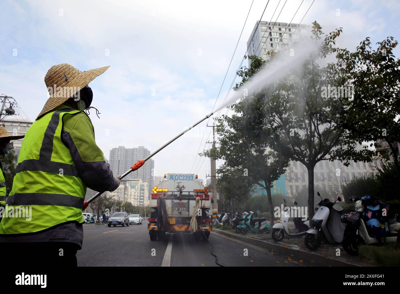 LIANYUNGANG, CHINE - le 14 OCTOBRE 2022 - des travailleurs verts pulvérisent des arbres le long d'une route principale pour tuer des insectes à Lianyungang, province de Jiangsu, Chine, le 14 octobre 2 Banque D'Images