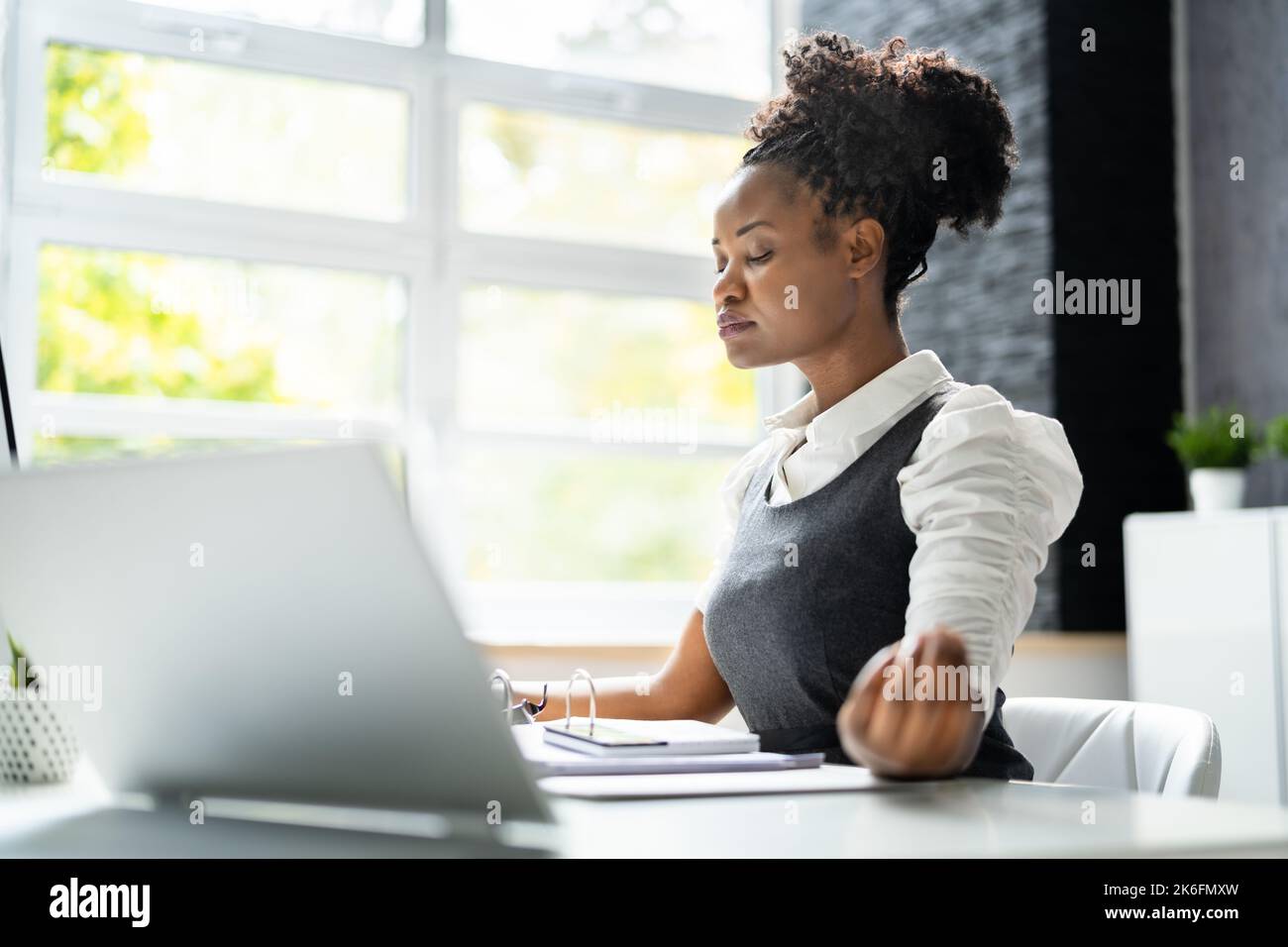 Méditation yoga à la réception. Femme d'affaires africaine américaine Banque D'Images