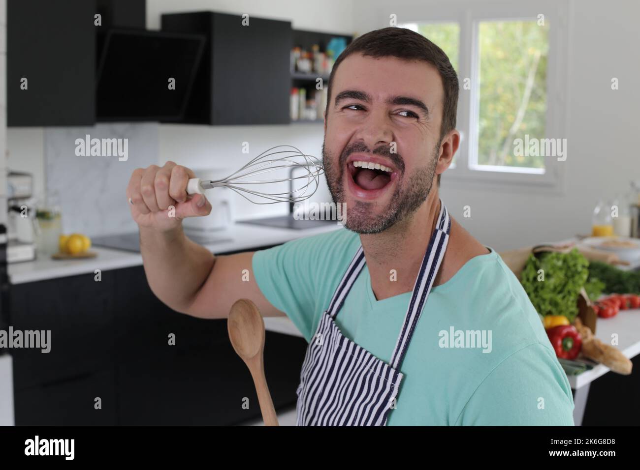 Homme chantant dans la cuisine Banque D'Images