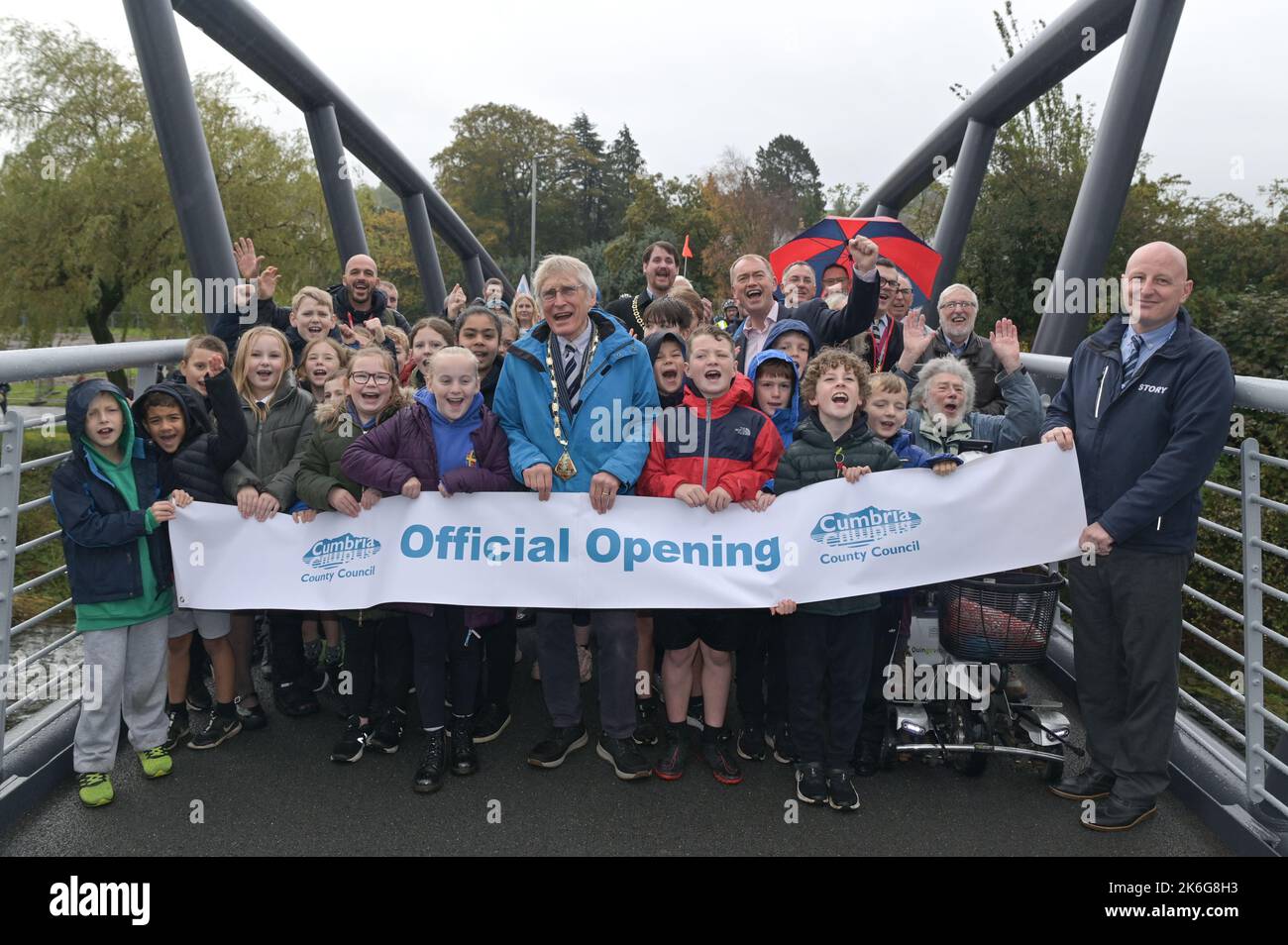 New Road, Kendal - 14 octobre 2022 - Pont Gooseholme à Kendal officiellement ouvert vendredi 14 octobre par le président du conseil du comté de Cumbria (CCC), Cllr Andy Connell avec des enfants de l'école Stramongate à proximité (tous autorisés pour les photos). Le député Tim Farron a aussi fait une apparition. La passerelle, qui coûte 2 millions de livres, a remplacé un vieux pont plus petit qui a été endommagé à Storm Desmond qui a frappé la ville en 2015, causant des inondations dévastatrices. La structure monstrueuse a été mise en place en juillet avec des touches finales réalisées au cours des derniers mois. CCC, en collaboration avec l'entrepreneur Story Contractin Banque D'Images