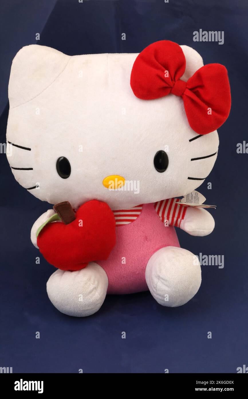 Hello Kitty jouet doux avec noeud rouge et tenue d'une pomme rouge Banque D'Images