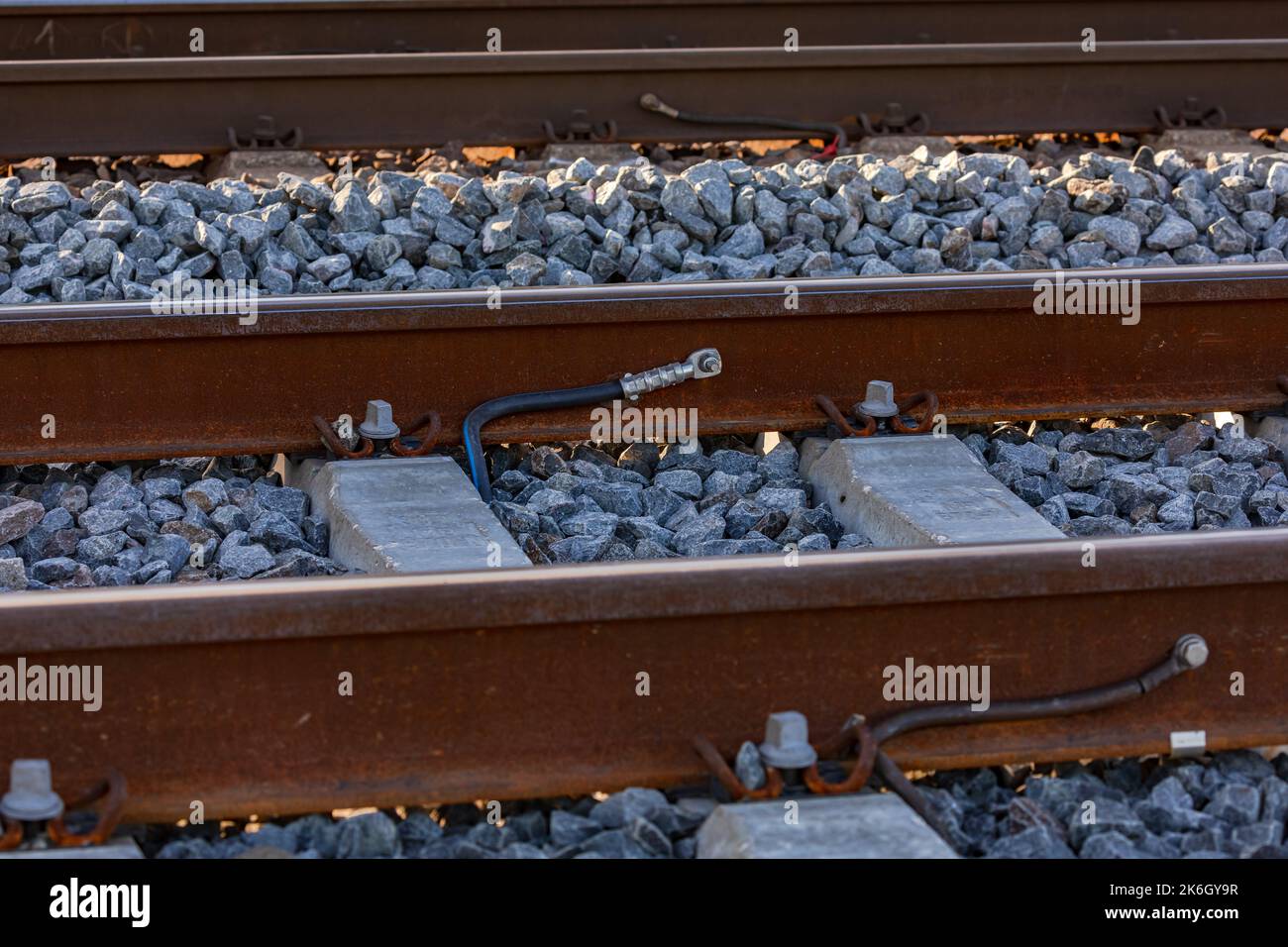 Cosses de câble sur un rail sur une voie ferrée dans un banc de ballast Banque D'Images