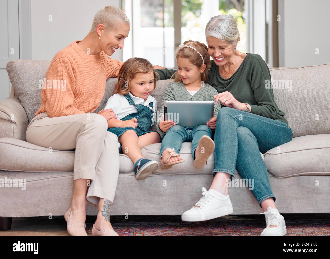 Pas de place pour la négativité. une femme mûre se liant avec sa fille et ses petits-enfants tout en utilisant une tablette numérique. Banque D'Images