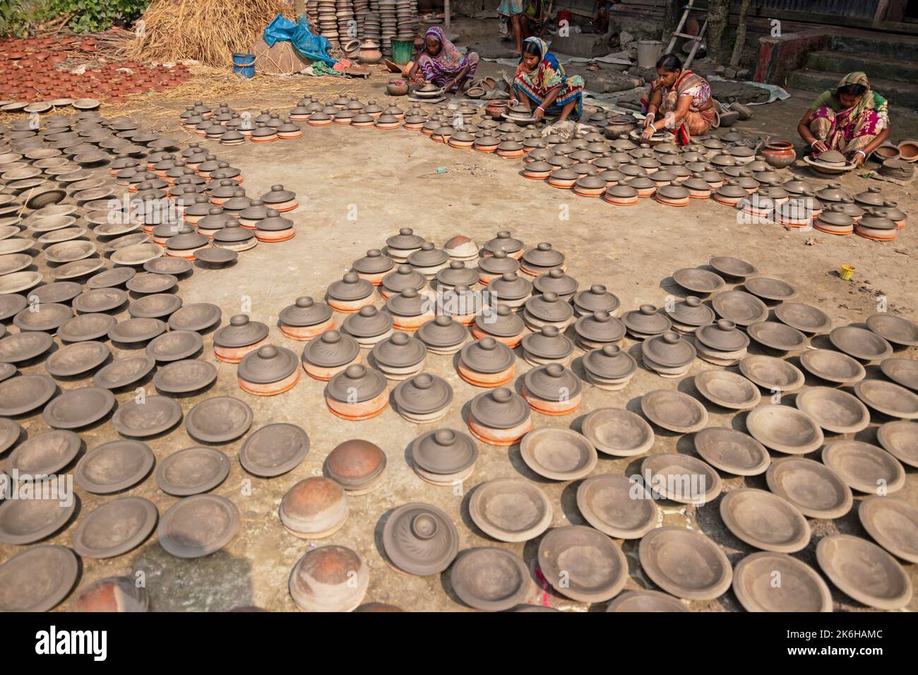 Les travailleurs font des pots d'argile comme une forme d'affaires de poterie à vendre sur un marché. Les pots d'argile sont disposés pour sécher sous le soleil. Banque D'Images