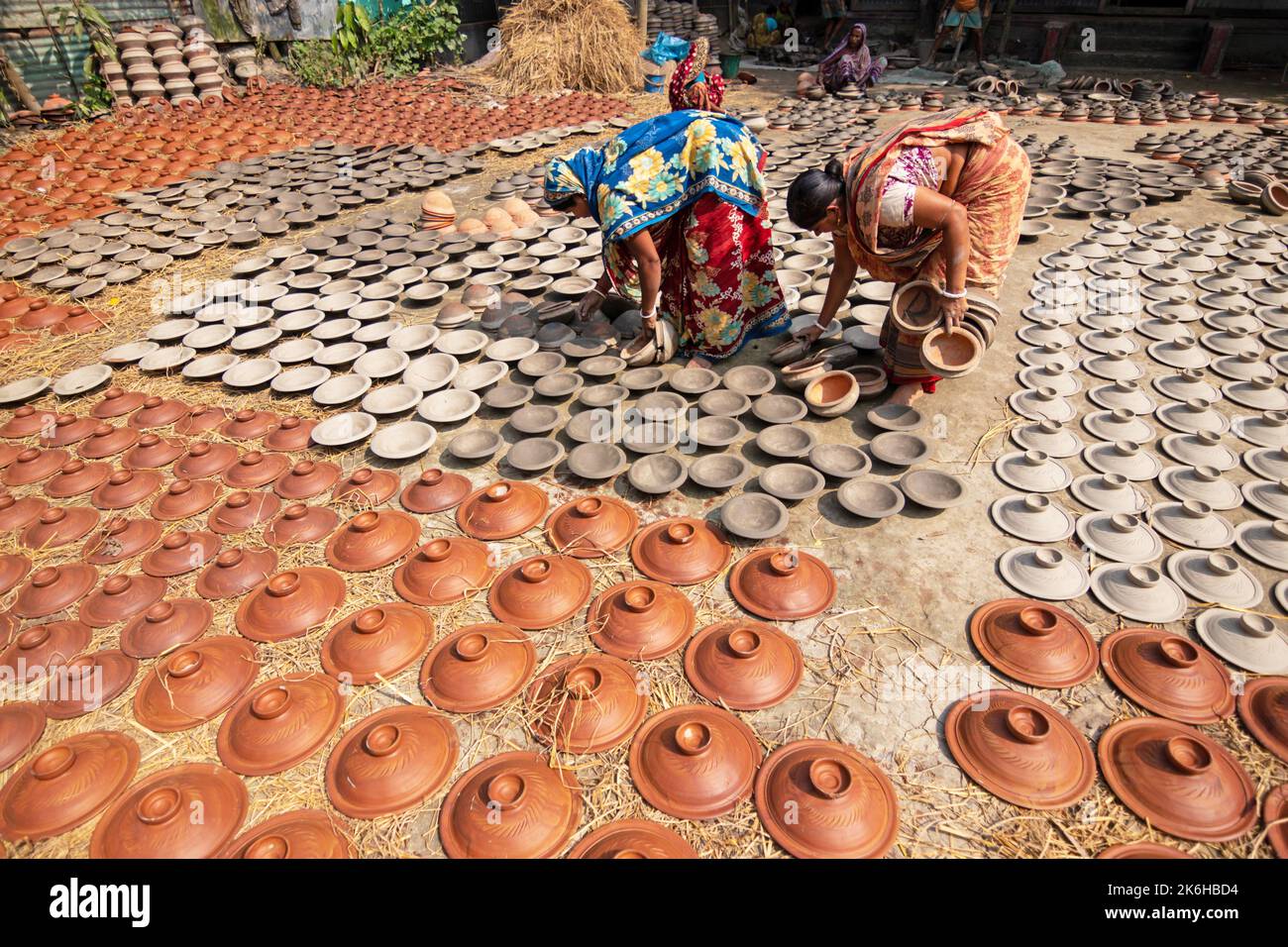 Les travailleurs font des pots d'argile comme une forme d'affaires de poterie à vendre sur un marché. Les pots d'argile sont disposés pour sécher sous le soleil. Banque D'Images