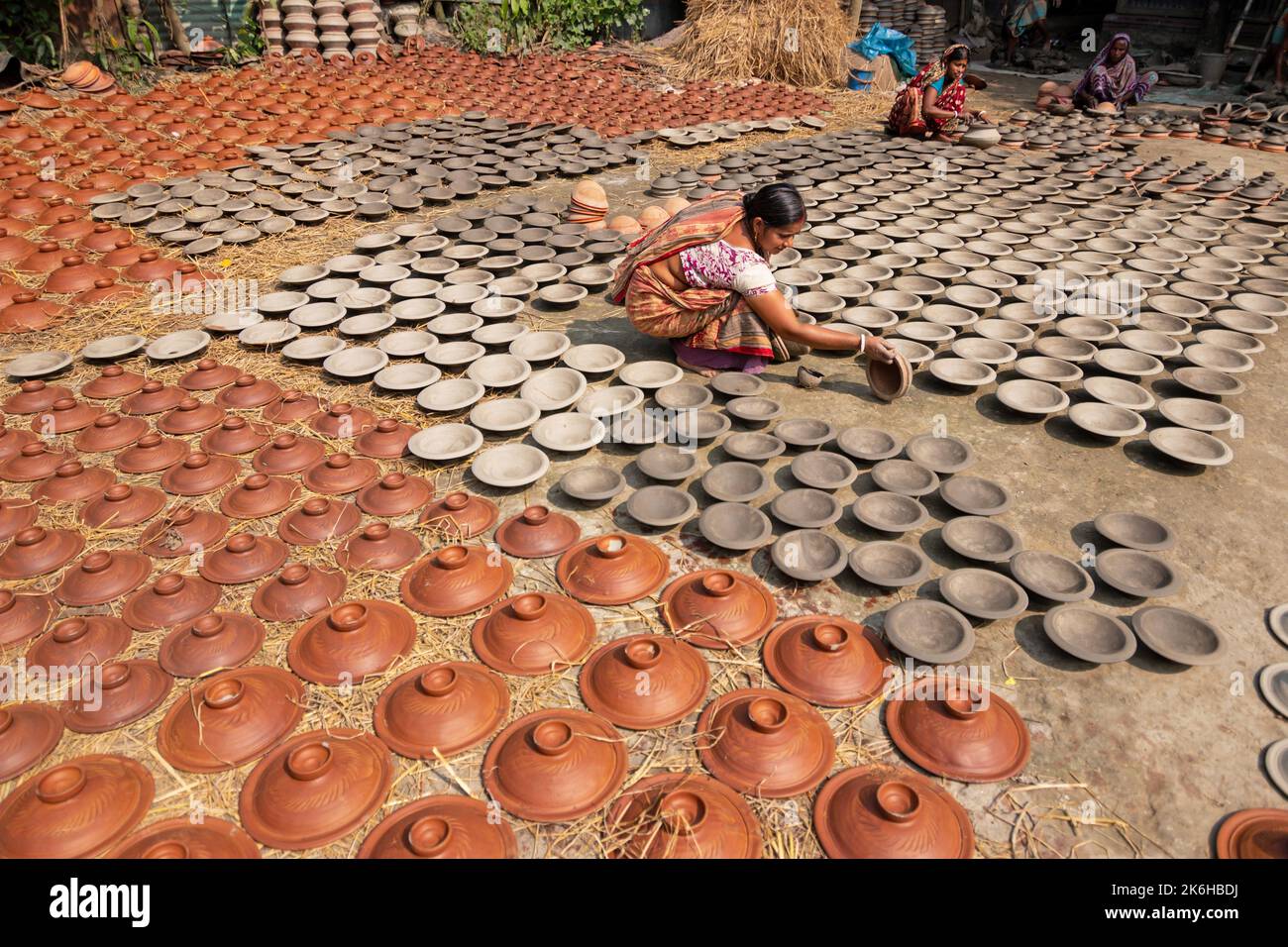 Les travailleurs font des pots d'argile comme une forme d'affaires de poterie à vendre sur un marché. Les pots d'argile sont disposés pour sécher sous le soleil. Banque D'Images