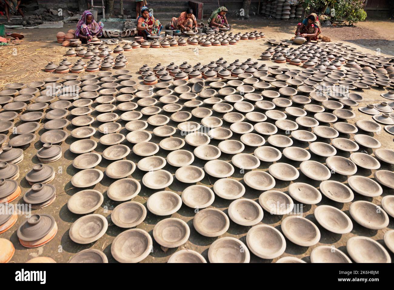 Les travailleurs font des pots d'argile comme une forme d'affaires de poterie à vendre sur un marché. Les pots d'argile sont disposés pour sécher sous le soleil. Banque D'Images