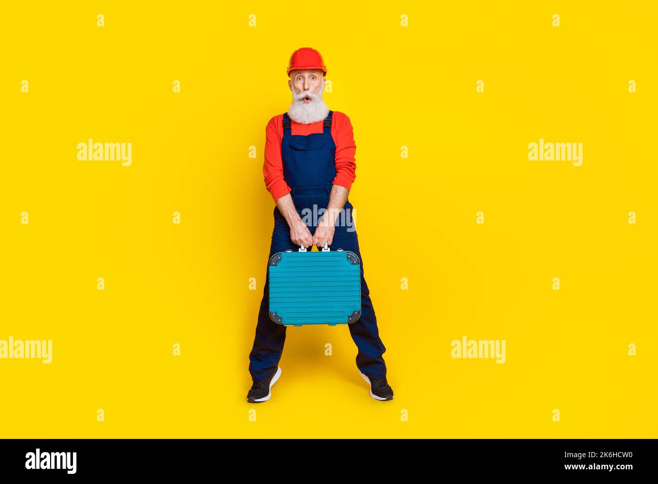 Photo pleine longueur d'un ouvrier expérimenté, kit de boîte à outils de maintien impressionné isolé sur fond de couleur brillante Banque D'Images