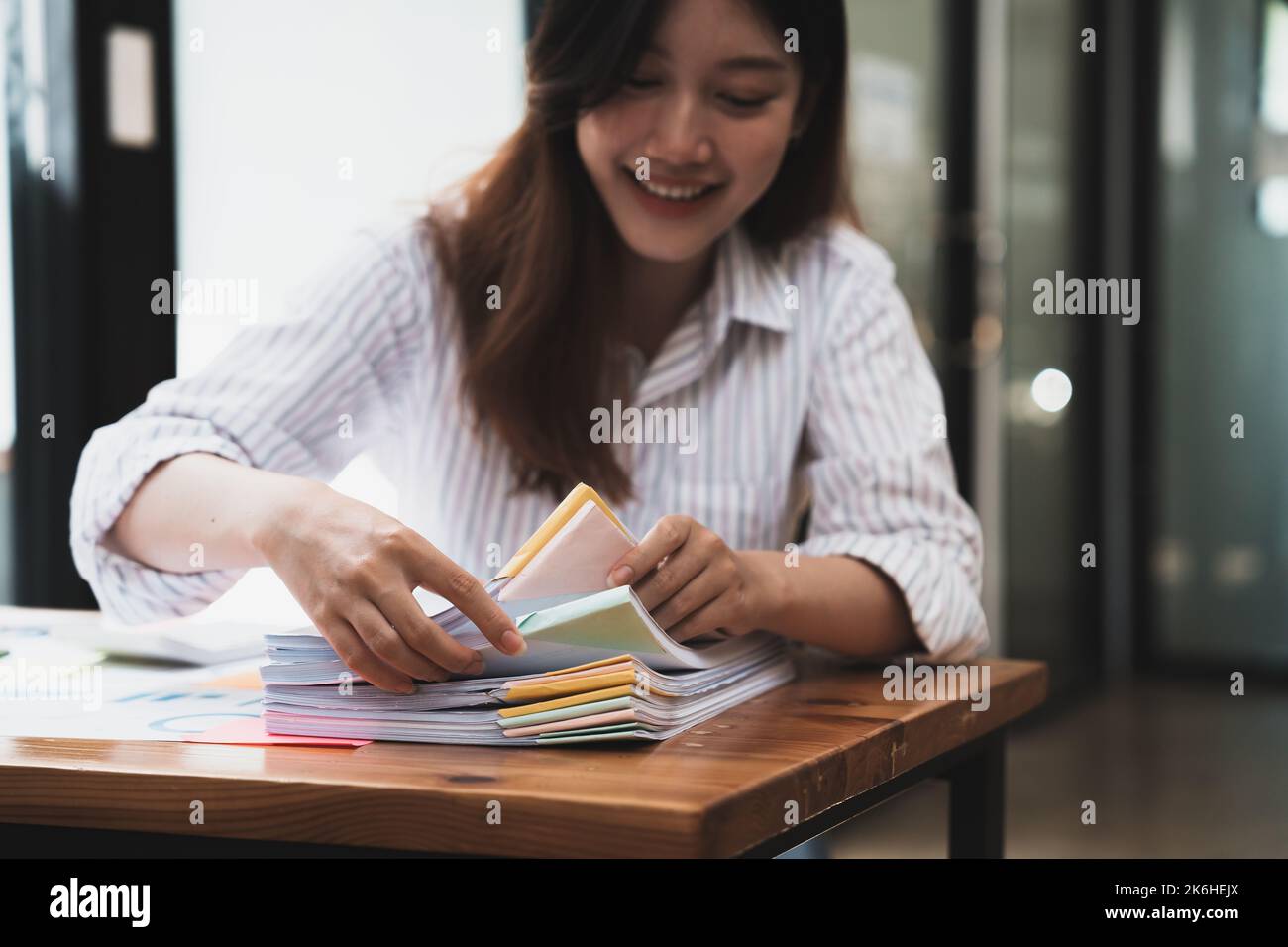 Les employés travaillent dans des piles de dossiers papier pour rechercher et vérifier les documents non terminés sur des dossiers de papiers. comptabilité d'entreprise Banque D'Images