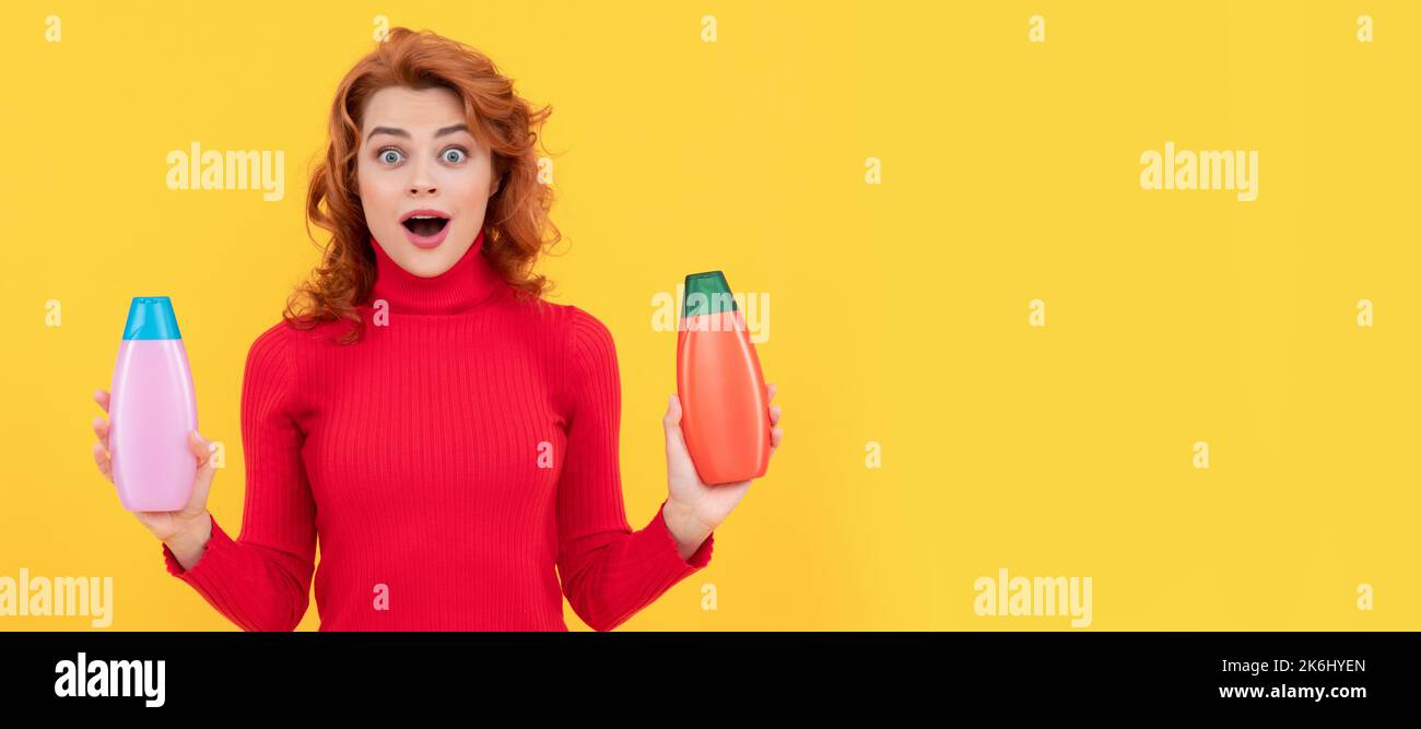 surprise redhead fille richement teint cheveux choisissant le produit de soins du corps de bouteille de shampooing, coiffeur Banque D'Images