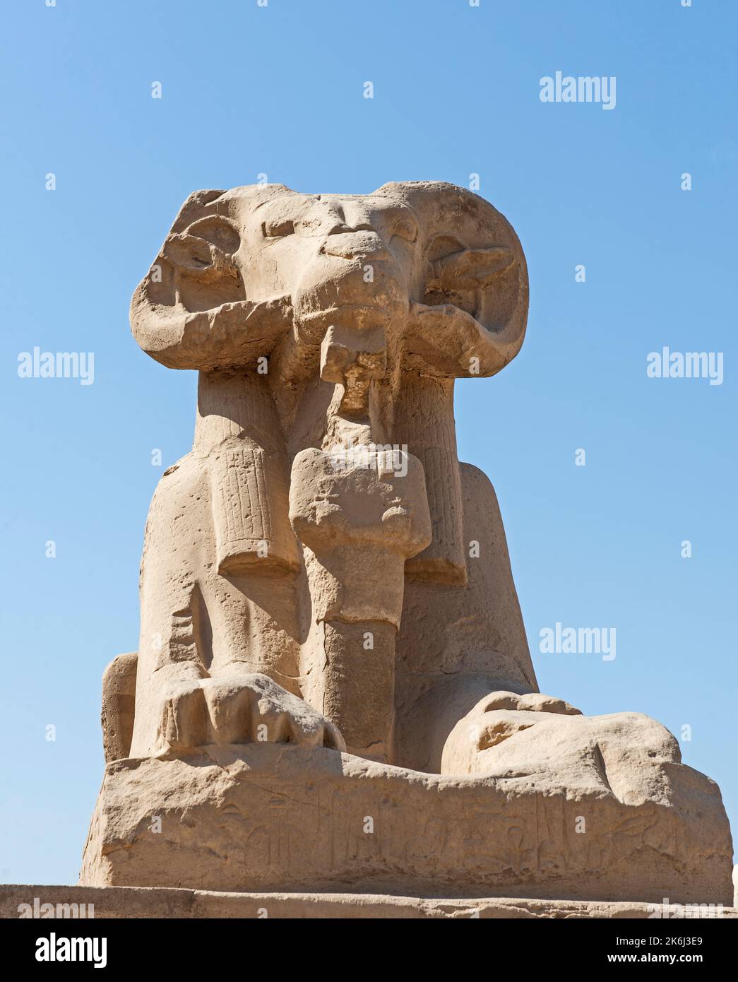 Grande statue de sphinx à tête de bélier dans l'ancien temple égyptien de Karnak avec fond de ciel de lue Banque D'Images