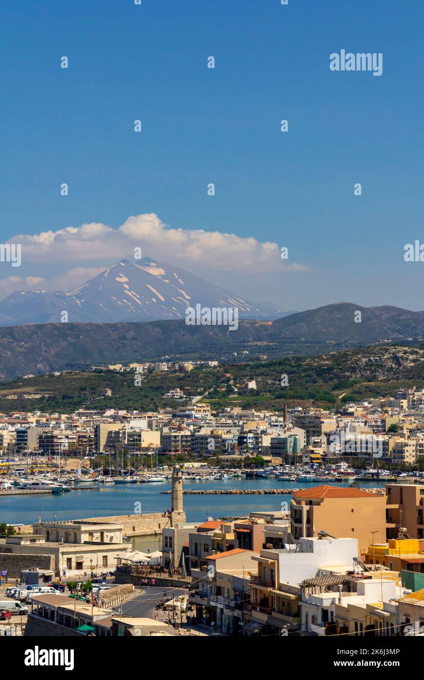 Vue sur la ville de Rethymno ou Rethymnon une station balnéaire sur la côte nord de la Crète en Grèce avec des montagnes enneigées au loin. Banque D'Images