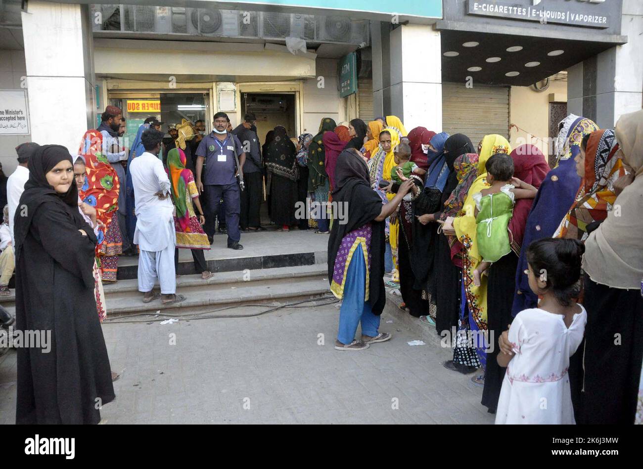 Un grand nombre de femmes pauvres bénéficiaires du Programme de soutien du revenu Benazir Bhutto (BISP) se réunissent à leur tour pour obtenir de l'argent dans une banque située sur la route Autobahn à Hyderabad vendredi, 14 octobre 2022. Banque D'Images