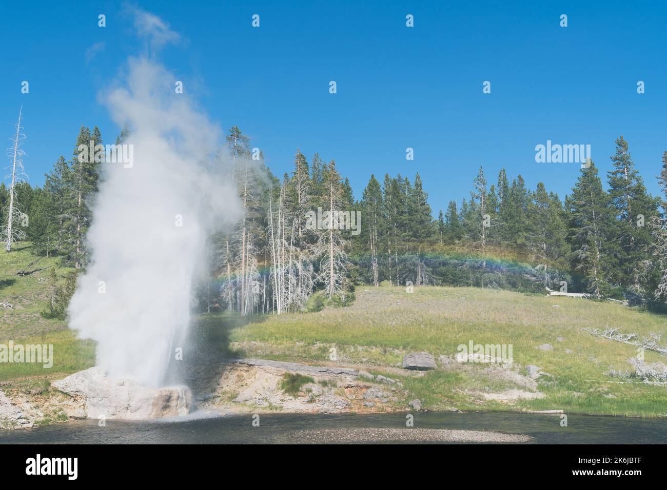 Riverside Geyser dans le parc national de Yellowstone éclate avec un arc-en-ciel complet Banque D'Images