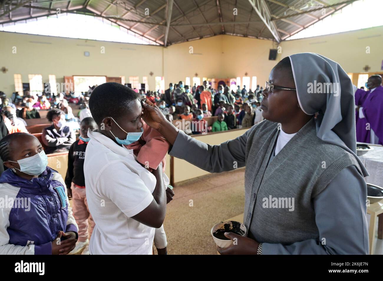 KENYA, Eldoret, Église catholique, mercredi des cendres, début de la saison prêtée, jour Saint de prière et de jeûne, marquant une croix de cendres sur le front / KENIA, Eldoret, Katholische Kirche, Gottesdienst zum Aschermittwoch, Beginn der Fastenzeit vor Ostern, Markierung eines Asche Kreuz auf der Stirn Banque D'Images