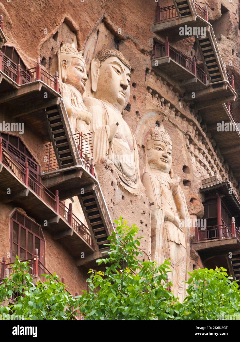 Les escaliers et la gravité défiant la grande passerelle / escaliers et les allées attachées à la roche fine ont permis aux visiteurs de contact étroit avec les figures d'argile et les anciennes sculptures en pierre. Le site de représentations / figures bouddhistes représentations et d'images de Bouddha (certaines semblent être très récemment restaurées en béton) sur la face rocheuse des Grottes de Maijishan, autrefois romanisé comme Maichishan, une série de 194 grottes coupées sur le côté des montagnes de Majishan à Tianshui, province de Gansu, Chine. PRC. (67/126) Banque D'Images