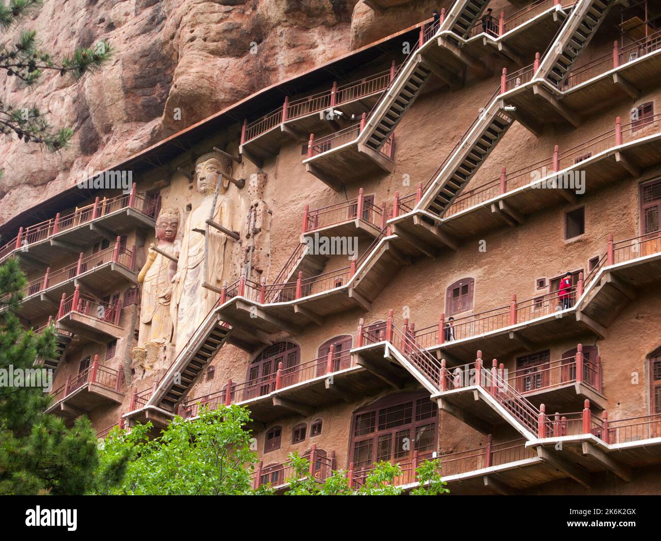 Les escaliers et la gravité défiant la grande passerelle / escaliers et les allées attachées à la roche fine ont permis aux visiteurs de contact étroit avec les figures d'argile et les anciennes sculptures en pierre. Le site de représentations / figures bouddhistes représentations et d'images de Bouddha (certaines semblent être très récemment restaurées en béton) sur la face rocheuse des Grottes de Maijishan, autrefois romanisé comme Maichishan, une série de 194 grottes coupées sur le côté des montagnes de Majishan à Tianshui, province de Gansu, Chine. PRC. (67/126) Banque D'Images