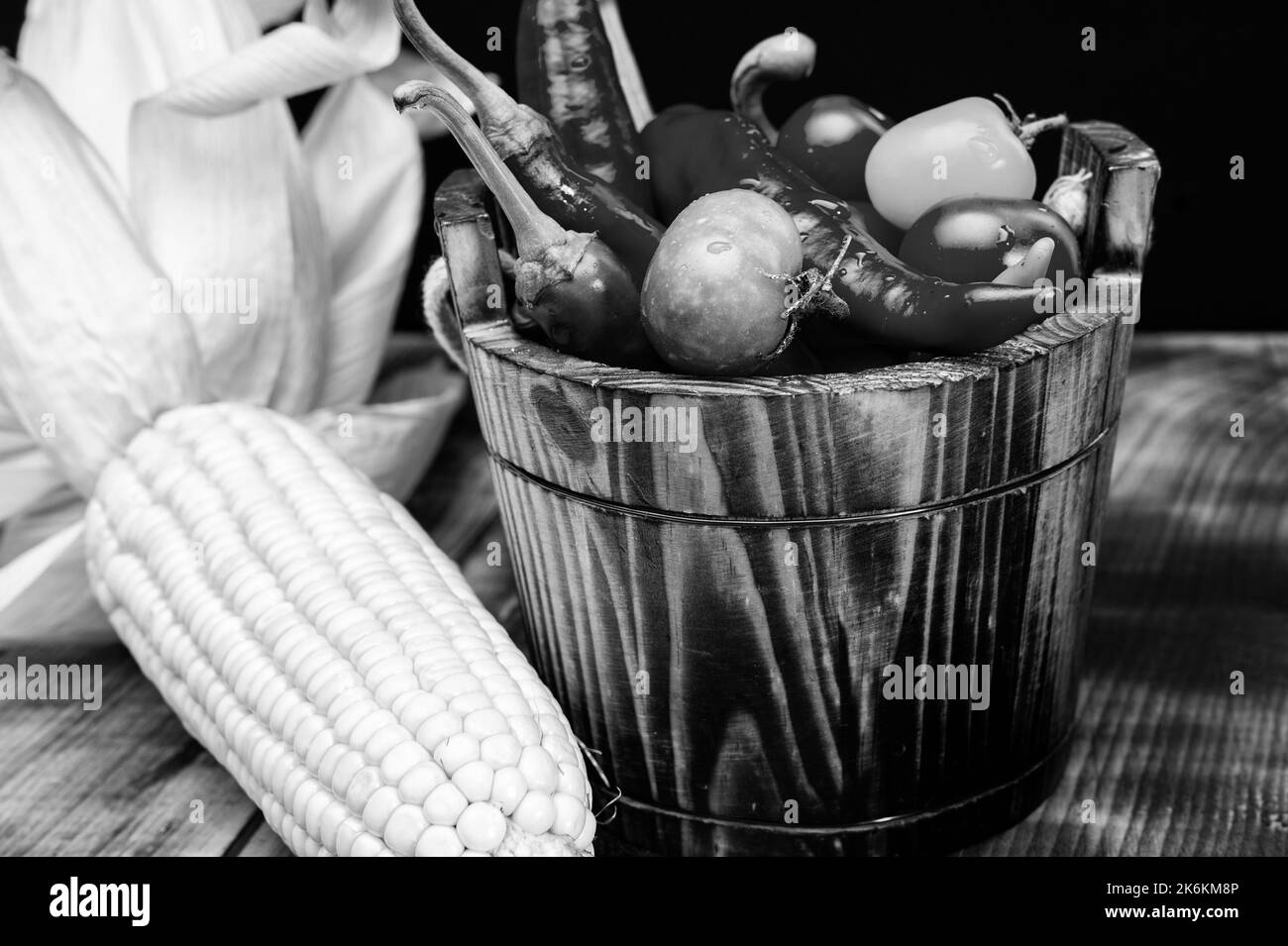 Épis de maïs avec piments et tomates légumes frais nourriture naturelle dans seau en bois, bio Banque D'Images