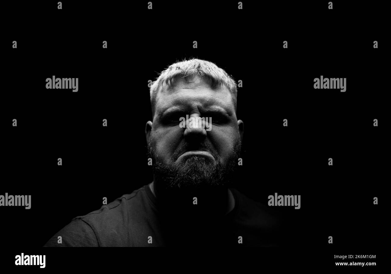 Homme regardant dans la caméra avec une expression malheureuse. Banque D'Images