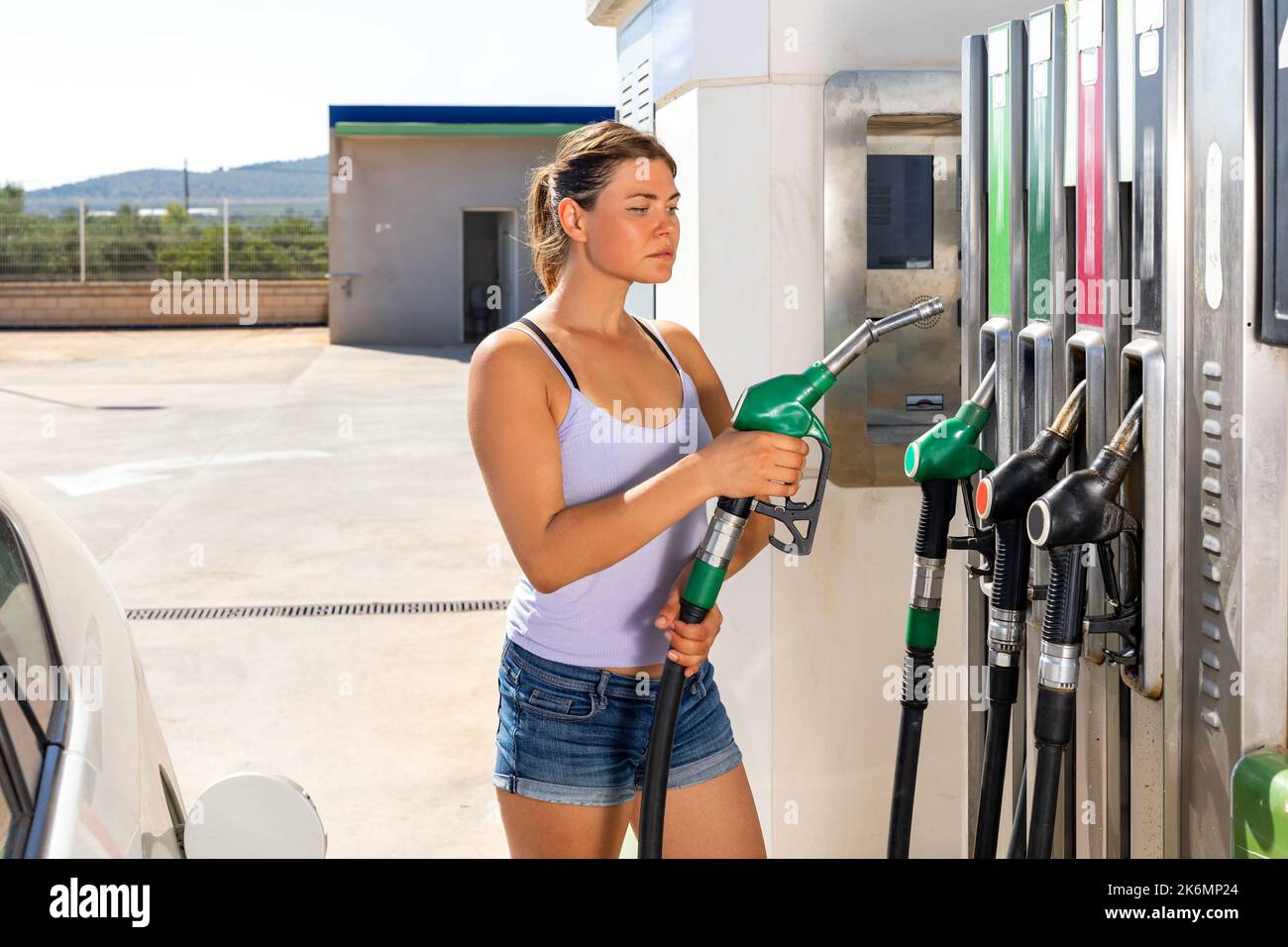 Femme ravitaillant sa voiture à la station-service Banque D'Images