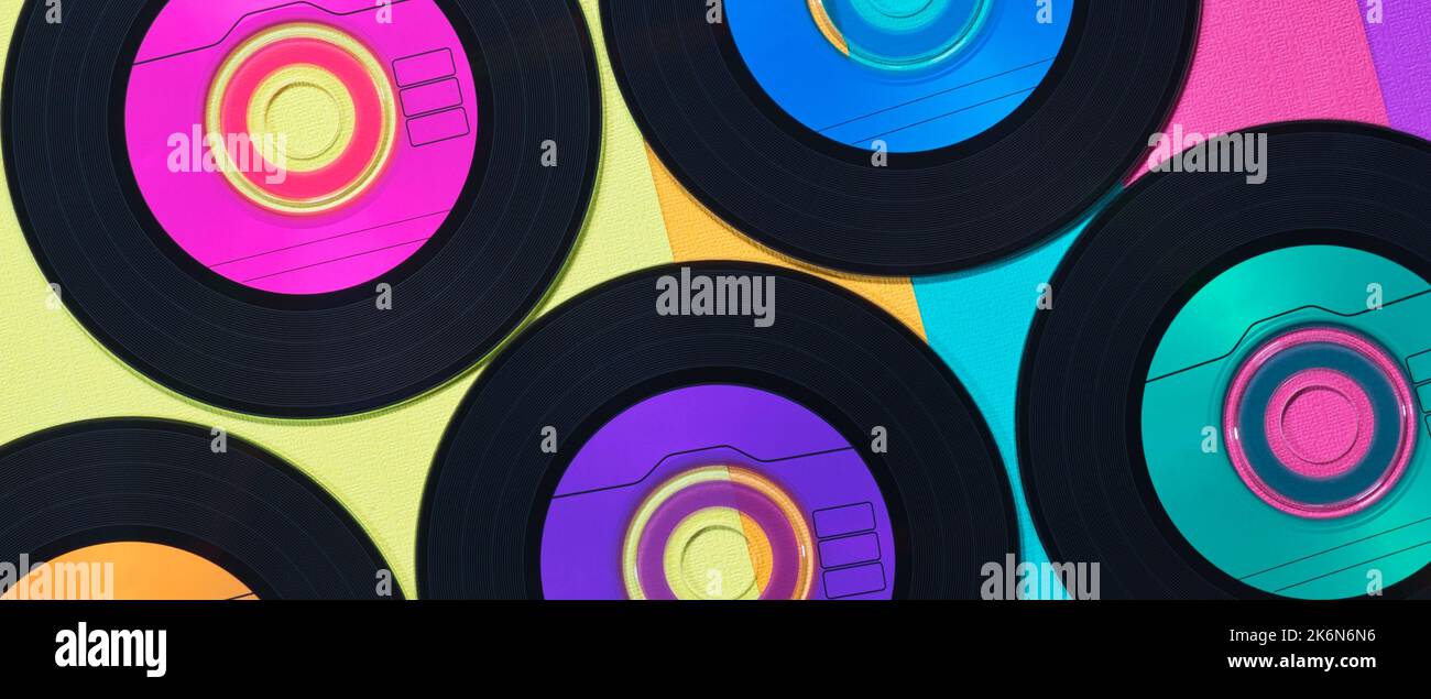 Disques CD en vinyle colorés au format de bannière plate sur fond multicolore, rétro enregistre une image conceptuelle. Banque D'Images
