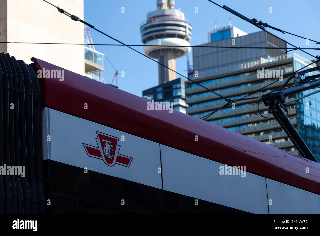 Le logo de la TTC, Toronto Transit Commission est visible sur le côté d'un tramway TTC, la Tour CN étant vue en arrière-plan. Banque D'Images