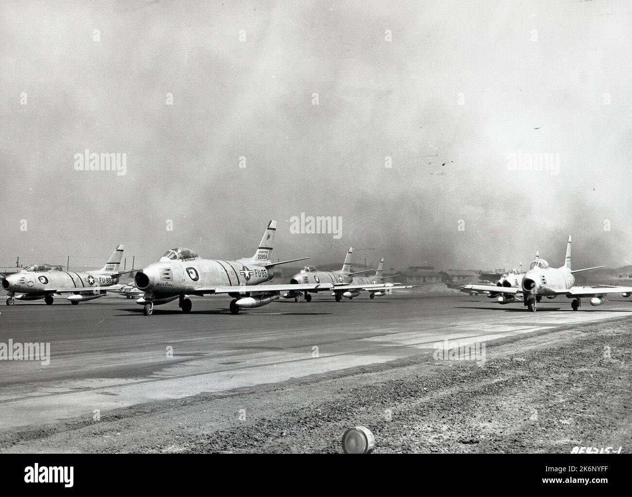 Photographie des F-86 Sabre Jets en Corée. Photographie des F-86 Sabre Jets en Corée. « L'une des deux photos prises sur une base de combat en Corée illustre, sous deux angles différents, ce moment de la guerre aérienne contre les communistes lorsque les États-Unis sont morts Les avions F-86 de la Force aérienne de l'aile Fighter-Interceptor 4th sont sur le point de crier vers le nord. On peut presque sentir les sifflements et les vibrations de la puissance des jets massés alors que les pilotes de « rage » mettent leurs moteurs en marche juste avant le décollage, envoyant des panaches de fumée épaisses et noires s'échappant des tuyaux de queue. Notez la vue frontale des tueurs MIG, prêts à l'emploi. A m Banque D'Images