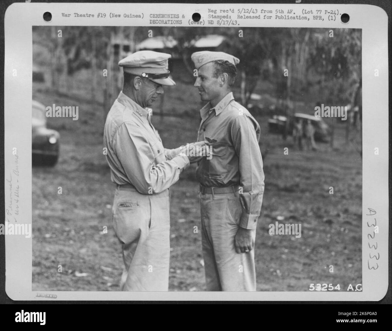 Le major Harvey J. Scandrett, de North Hollywood, en Californie, est décoré de la Médaille de l'air, de la Croix de vol distinguée et de l'étoile d'argent, par le lieutenant-général George C. Kenney. Le major était l'un des 16 pilotes de poursuite à décorer la veille Banque D'Images