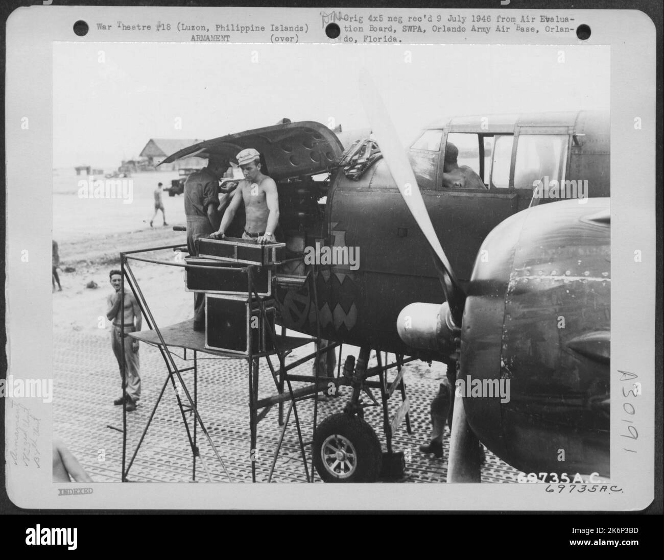 Cinq minutes après l'atterrissage de l'avion à Clark Field, Luzon, aux Philippines, les armateurs étaient occupés à relocaliser les armes sur ce B-25 nord-américain du 823rd Bomb Squadron, 38th Bomb Group. 17 mai 1945. Banque D'Images