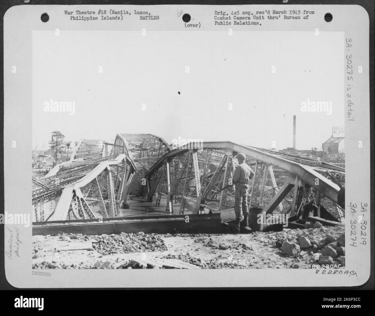 Un soldat recherche d'éventuels tireurs d'élite dans les ruines du pont Ayala, qui a traversé la rivière Pasig, Manille, Luzon, Philippines. Ce pont a été soufflé à la dernière minute en traitant les JAP qui ont ensuite défendu les approches au contraire Banque D'Images