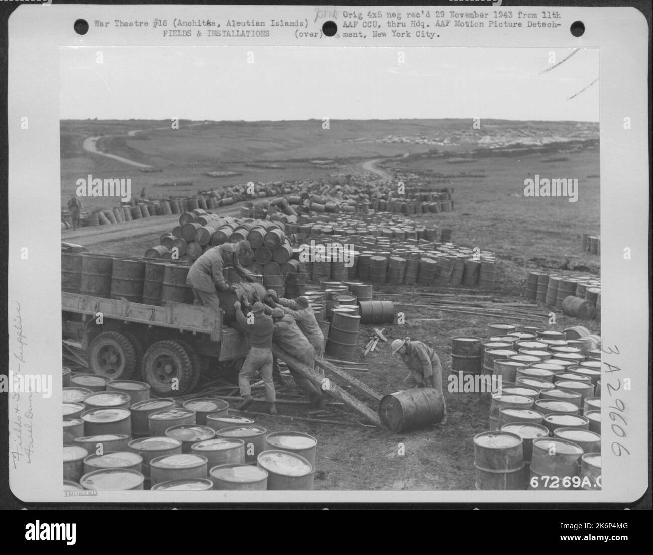 Chargement de barils de carburant sur un camion au niveau du déversement de carburant d'une base aérienne de 11th près d'Amchitca, dans les îles Aléoutiennes. 12 octobre 1943. Banque D'Images