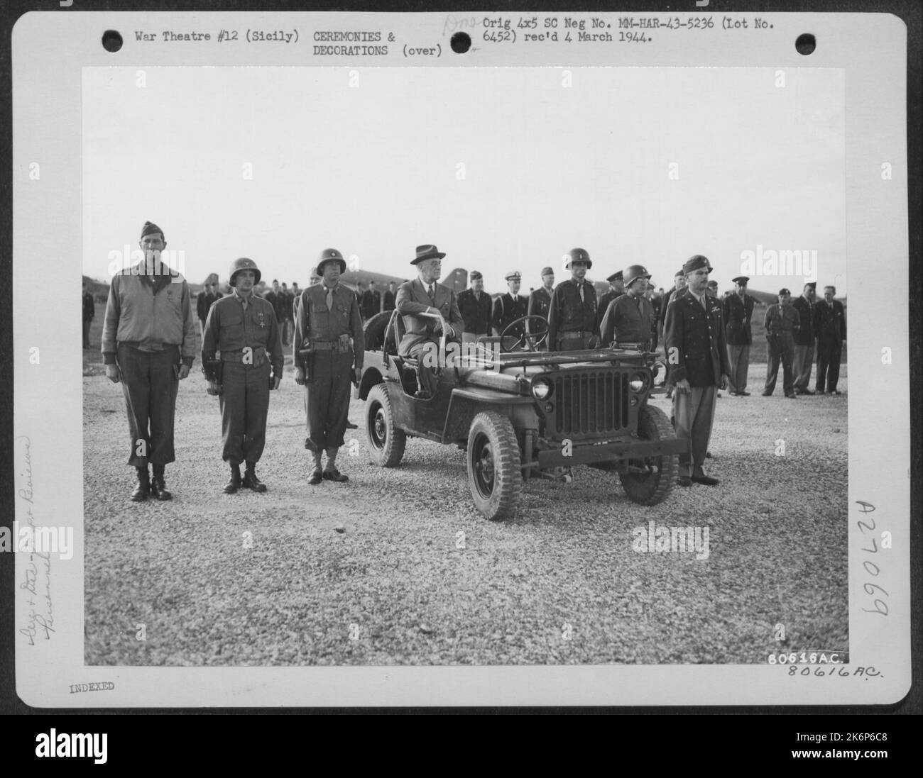 Le président Franklin D. Roosevelt est montré assis dans sa jeep lors d'une inspection des troupes de l'armée de l'air en Sicile, tandis que se tenant à l'attention de chaque côté sont six officiers de rang qui ont été présentés la Croix du service distingué par le Banque D'Images