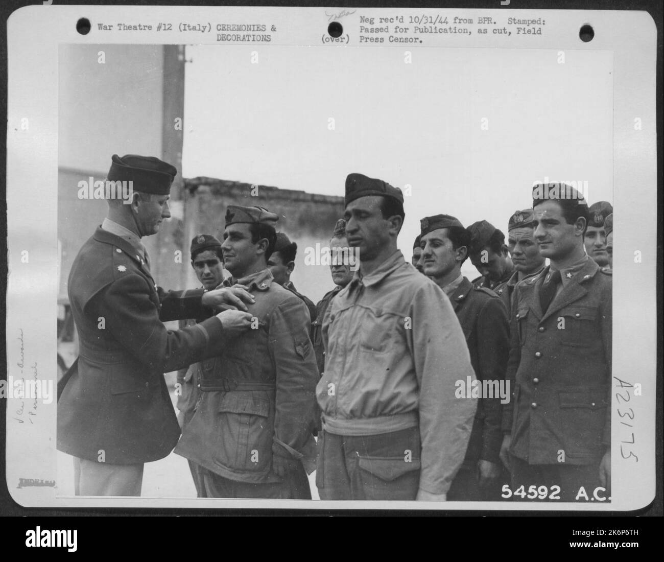 Le lieutenant-colonel Joseph G. Russell, de San Antonio (Texas), commandant d'un groupe de bombardiers libérateurs, porte la médaille des soldats sur le sergent Major Santo Tedono, un soldat italien né dans les plaines blanches, dans l'État de New York Avec le Sgt. Major Nicola Surdo, (debout à Banque D'Images