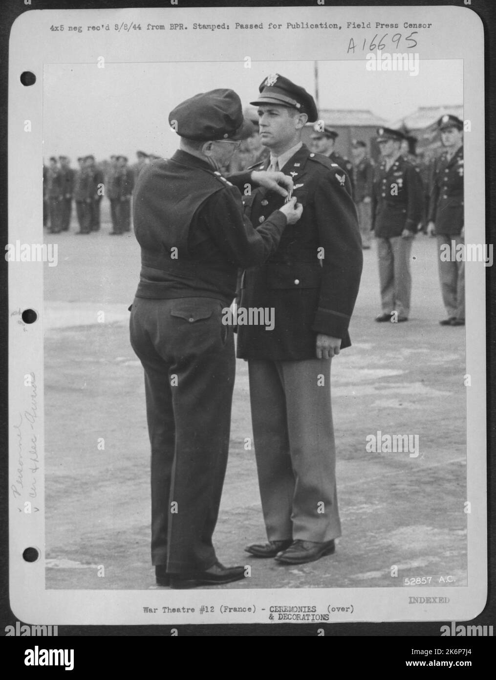 Le lieutenant-général Lewsi H. Brereton, commandant général de l'Armée de l'Air de 9th, enchaîne la Croix de vol distinguée sur le 1st lieutenant Charles C. Mish, 26 ans, South Boston, en Virginie, en cérémonies dans une base aérienne de 9th quelque part en FRANCE. Le prix était en reconnaissance du lieutenant. Banque D'Images