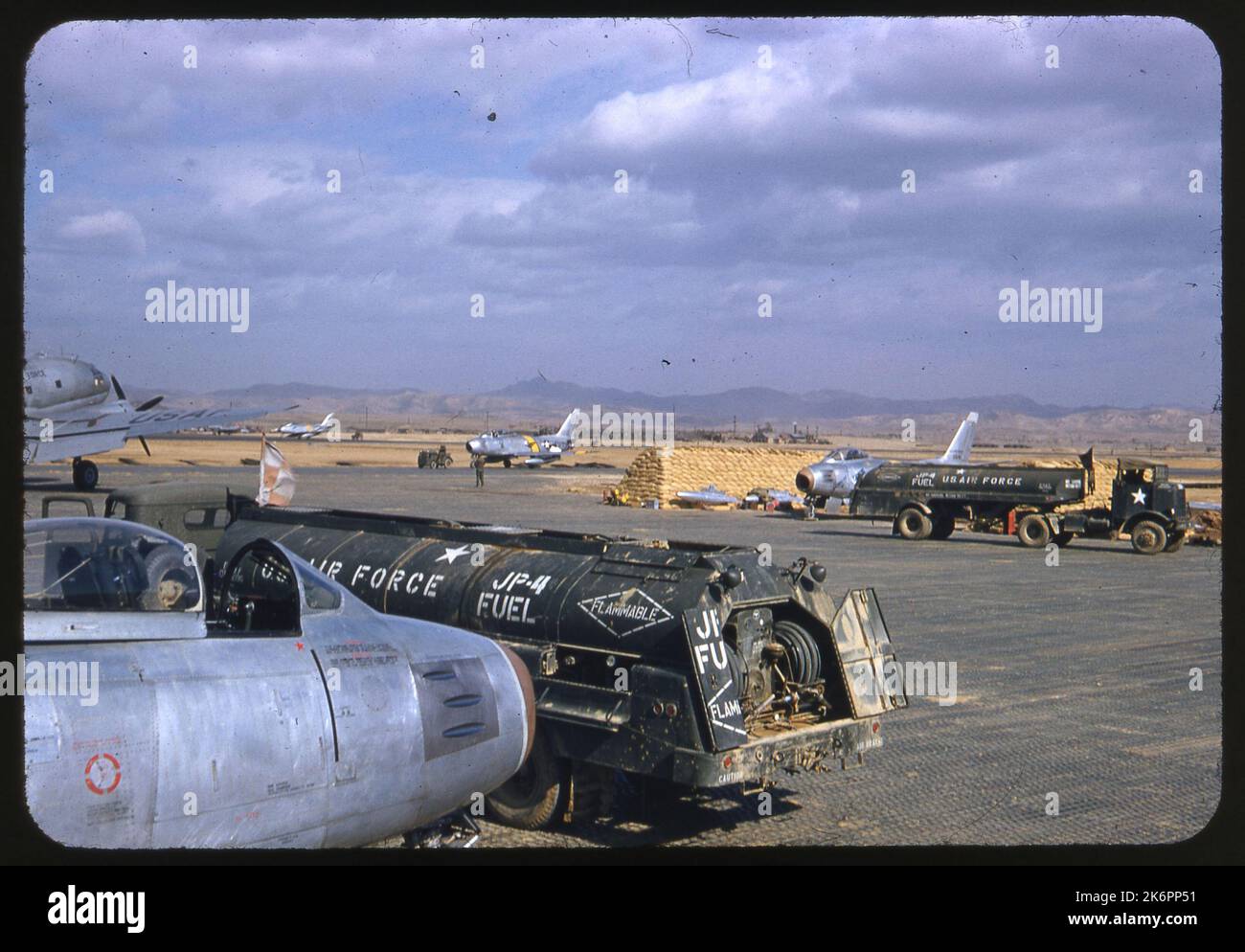 Plusieurs avions F-86 sabre nord-américains se ravitaillent en carburant alors qu'ils sont garés parmi des tas de sacs de sable. Plusieurs avions F-86 sabre nord-américains se ravitaillent en carburant alors qu'ils sont garés parmi des tas de sacs de sable. Banque D'Images