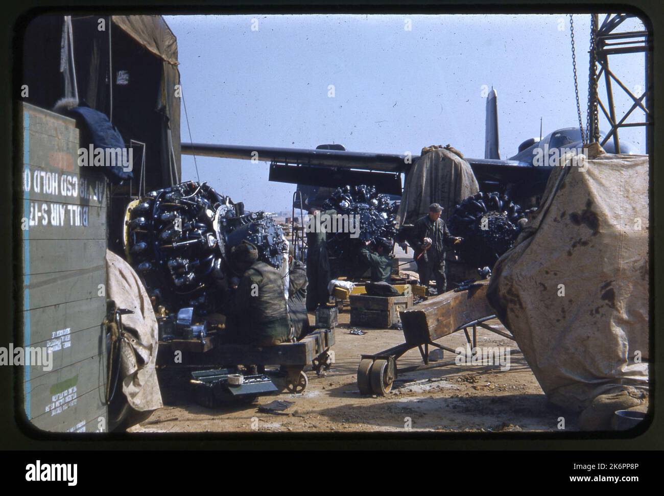 Zone de réparation du moteur, avec de nombreux moteurs et réparateurs. Un envahisseur Douglas RB-26C se cache en arrière-plan. Zone de réparation du moteur, avec de nombreux moteurs et réparateurs. Un envahisseur Douglas RB-26C se cache en arrière-plan. Banque D'Images