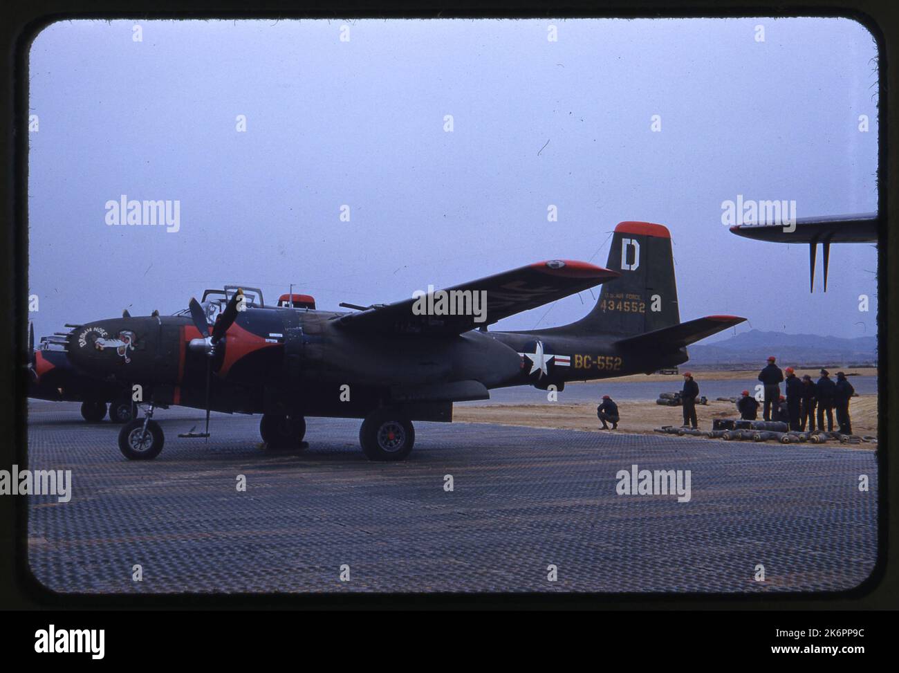 Vue du côté gauche d'un envahisseur Douglas B-26B (n° de série 44-34552; n° de série 27831), surnommé 'nez brun' avec art du nez, à la fin de la piste d'atterrissage. Les techniciens se tiennent juste à l'extérieur de la piste d'atterrissage en attente. Vue du côté gauche d'un envahisseur Douglas B-26B (n° de série 44-34552; n° de série 27831), surnommé 'nez brun' avec art du nez, à la fin de la piste d'atterrissage. Les techniciens se tiennent juste à l'extérieur de la piste d'atterrissage en attente. Banque D'Images