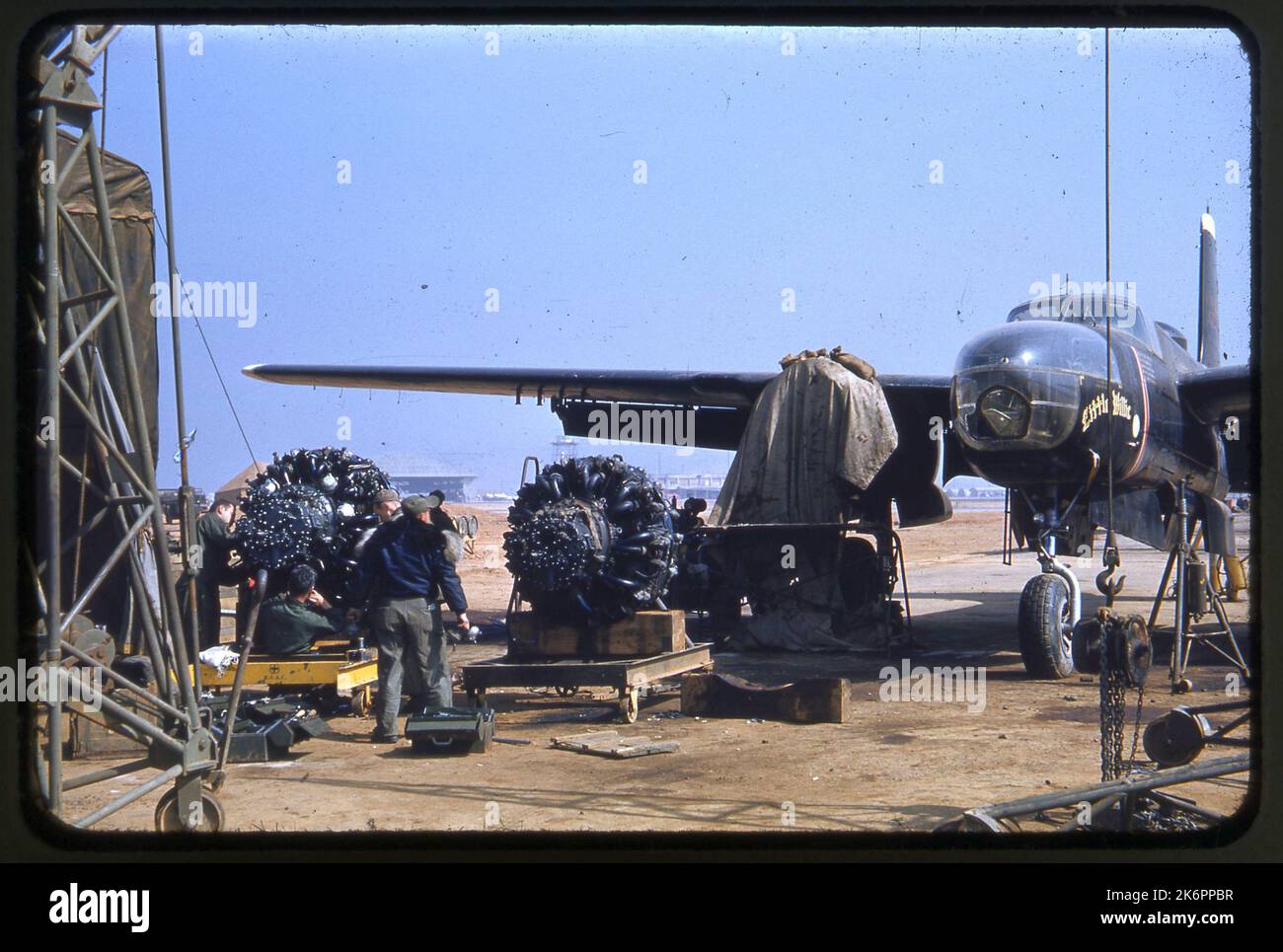 Travaillant à côté de l'avion, les réparateurs travaillent sur les deux moteurs d'un envahisseur Douglas RB-26C. Le surnom sur le nez de l'avion est « Little Debbie ». Travaillant à côté de l'avion, les réparateurs travaillent sur les deux moteurs d'un envahisseur Douglas RB-26C. Le surnom sur le nez de l'avion est « Little Debbie ». Banque D'Images