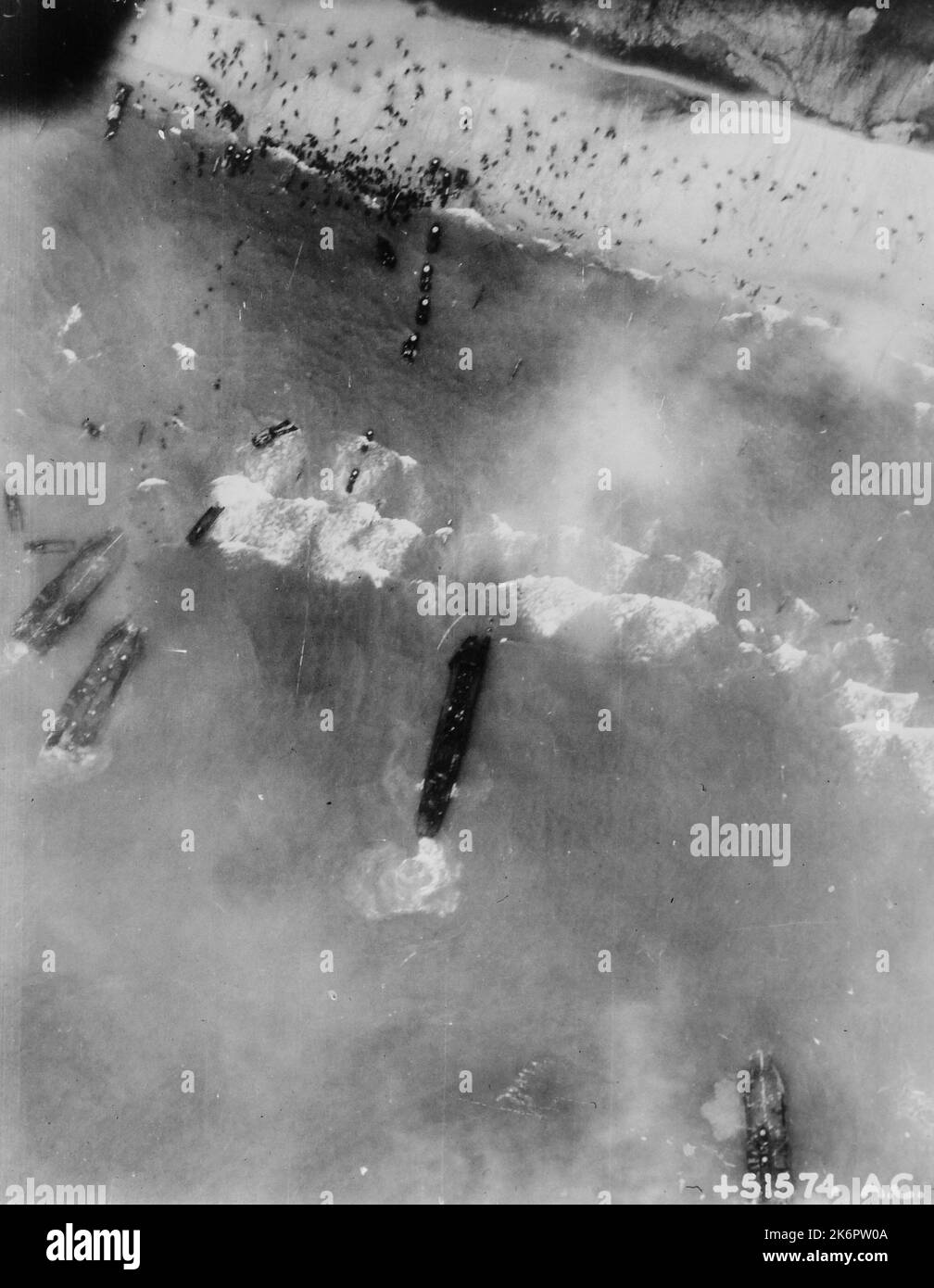 Photographie des hommes et des véhicules d'assaut sur les plages de Normandie. Photographie des hommes et des véhicules d'assaut sur les plages de Normandie. Des hommes et des véhicules d'assaut orageux sur les plages de Normandie tandis que les bateaux alliés font une brèche dans le mur ouest allemand sur 6 juin 1944. Tandis que vague après vague de bateaux d'atterrissage déchargent leur cargaison, les hommes se déplacent à l'intérieur des terres et les véhicules s'enroulent sur les routes. Notez que les hommes se balançent sur les plages. 1944-06-06T00:00:00. Banque D'Images