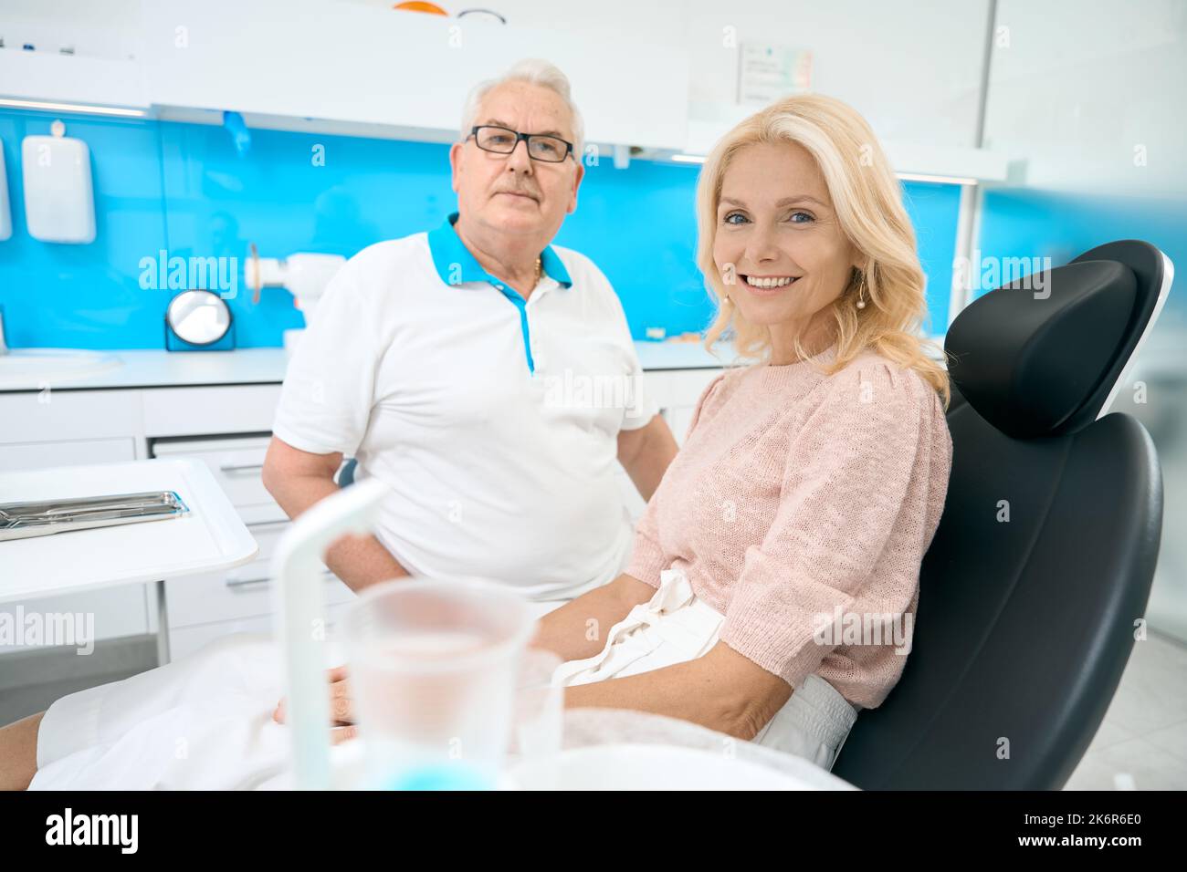 Femme souriante pendant le traitement dentaire professionnel dans le bureau de stomatologie Banque D'Images