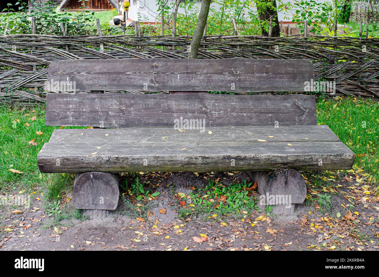 Banc en bois ancien traversé le long de la piste dans le parc en bois ancien banc en bois entouré dans une forêt entourée de feuilles d'automne Banque D'Images