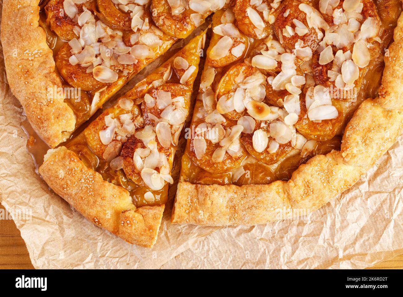Gros plan sur du papier parchemin, tarte maison aux prunes et aux pétales d'amande. Vue de dessus. Banque D'Images